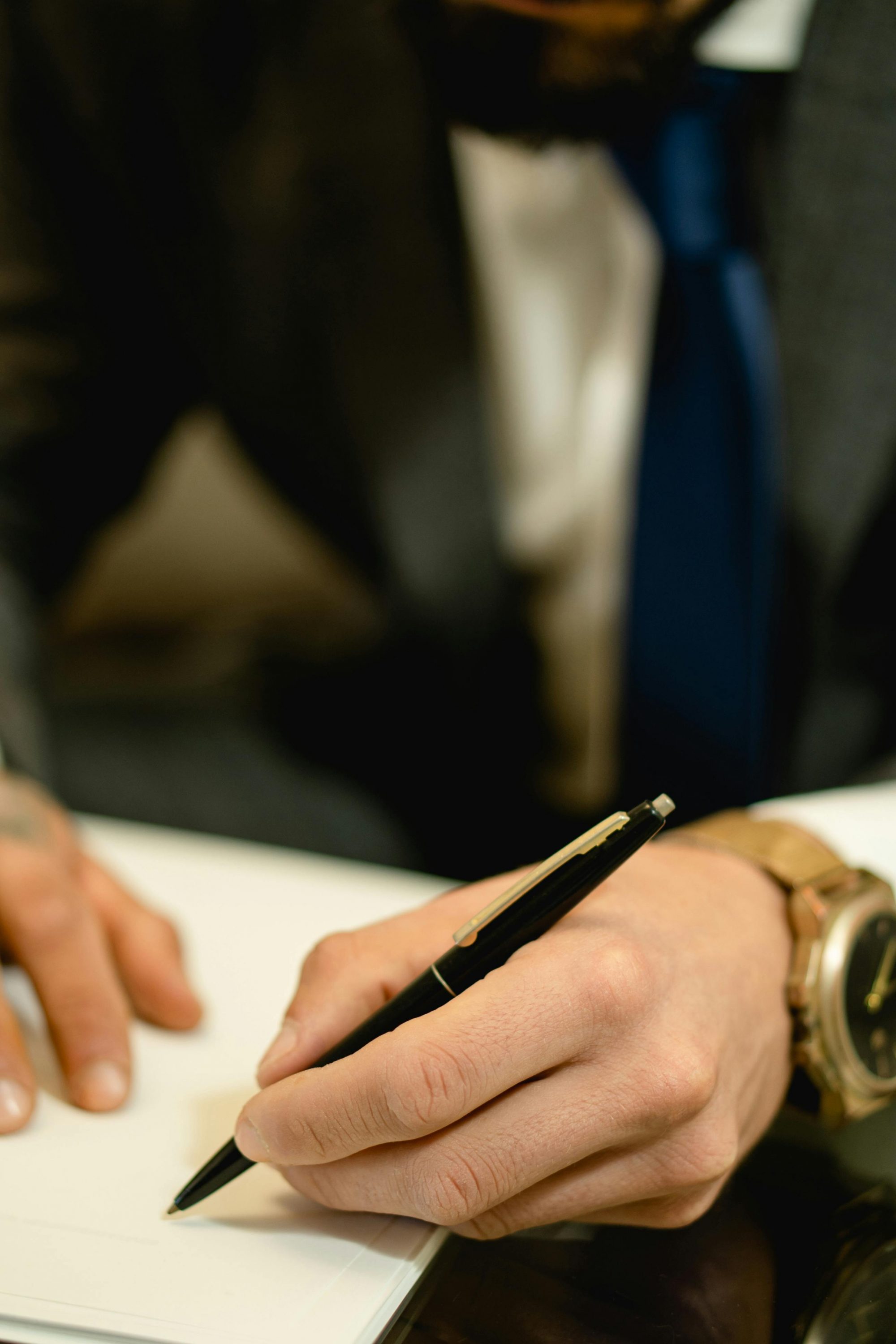 pexels-photo-7504780-7504780 Close-up of hand signing a legal contract with a pen. Ideal for business and legal themes.